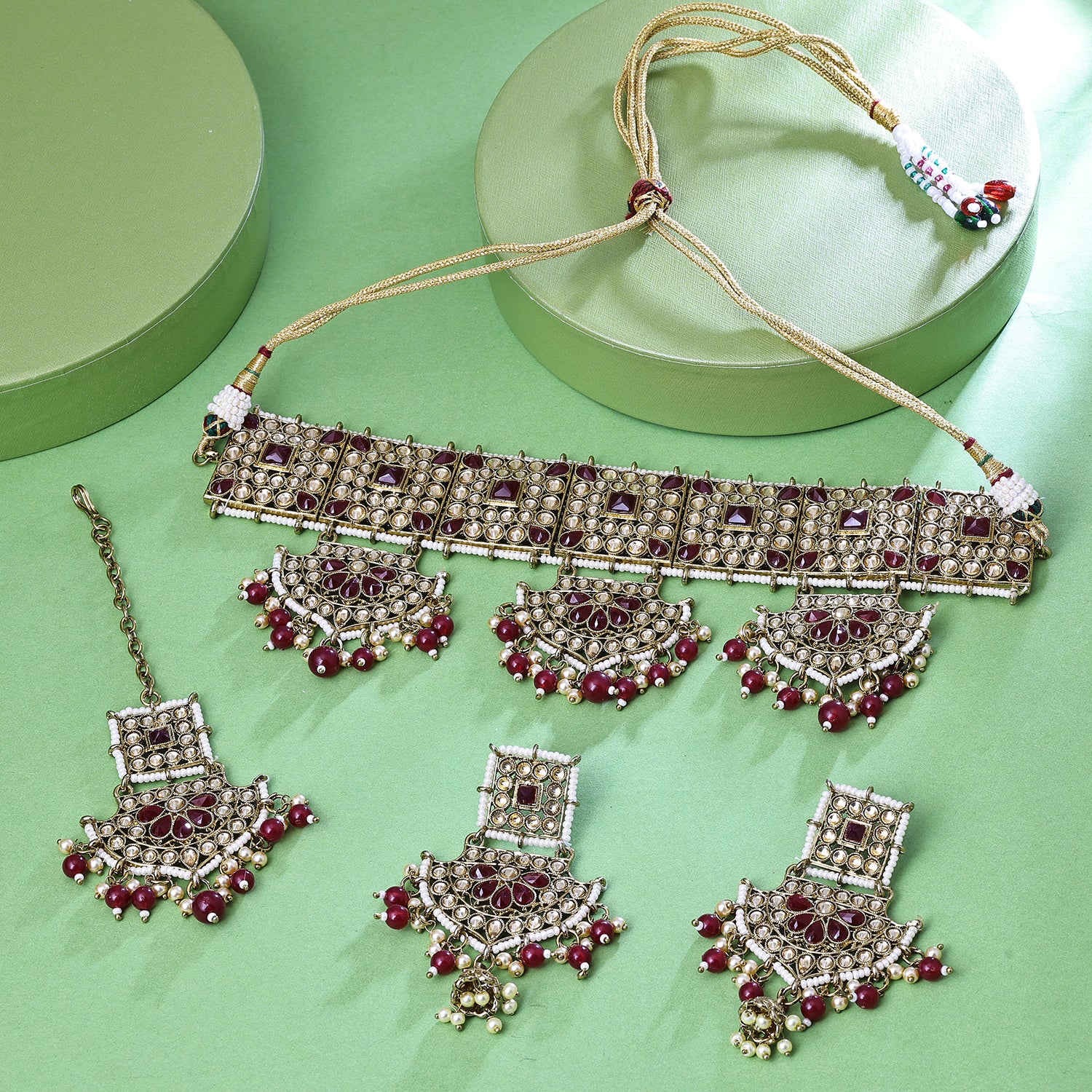Sukkhi Hypnotizing Gold Plated Maroon LCT Stone Collar Necklace Set With Maang Tikka for Women