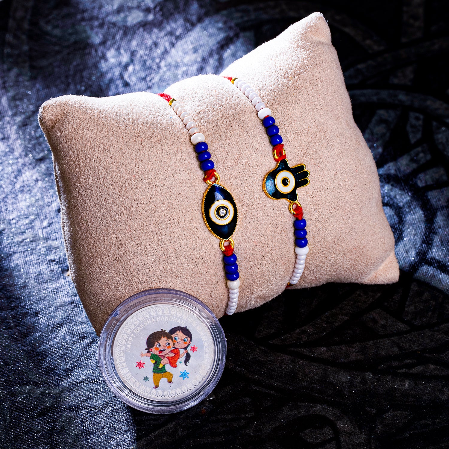 Sukkhi Classic Gold Plated Evil Eye Meenakari Rakhis Set of 2 & 2 Gram 999 Pure Silver Coin Combo with Roli Chawal and Rakhi Greeting Card