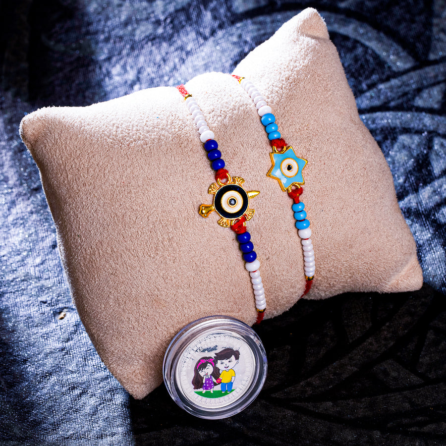 Sukkhi Trendy Gold Plated Evil Eye Meenakari Rakhis Set of 2 & 1 Gram 999 Pure Silver Coin Combo with Roli Chawal and Rakhi Greeting Card